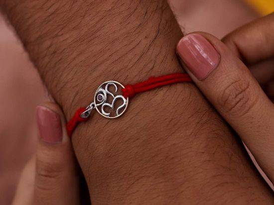 Aum Ruby Silver Rakhi Pendant on wrist