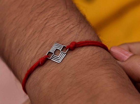 Square Motif Silver Rakhi Pendant on wrist