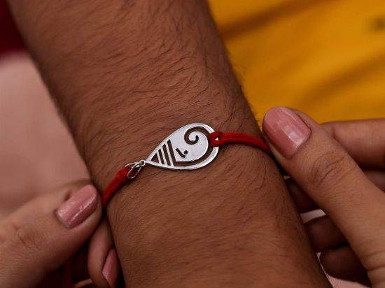 Gaurik Silver Rakhi Pendant on wrist