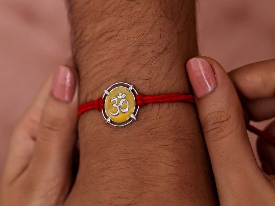 Meena Om Silver Rakhi on wrist